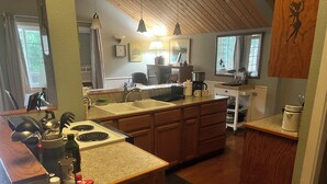 A kitchen with wooden cabinets, a stove, and a sink. There is a fire blanket on the counter. - Washougal River Front Apt. Pets OK
Close to Columbia Gorge, close to PDX (Washougal)