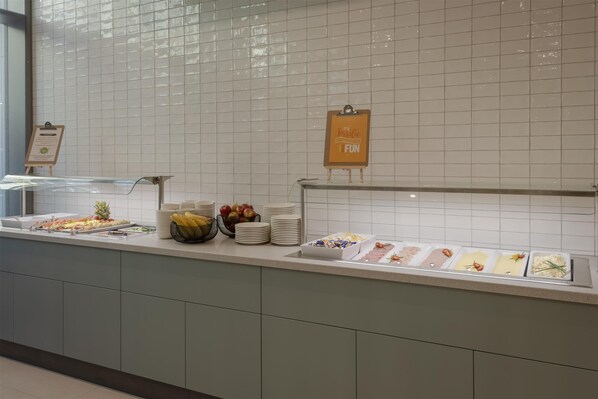A buffet counter with various food items and a sign that reads "Turtle FUN".