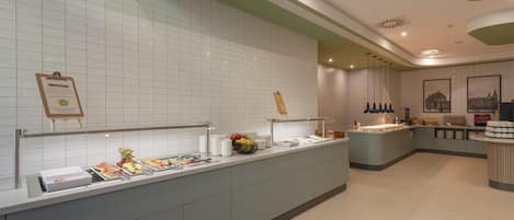 Zona de recepción de un hotel moderno con una pared limpia de azulejos y un mostrador tipo buffet.