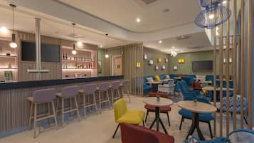 Eine moderne Bar mit Sitzgelegenheiten und einem Fernseher.