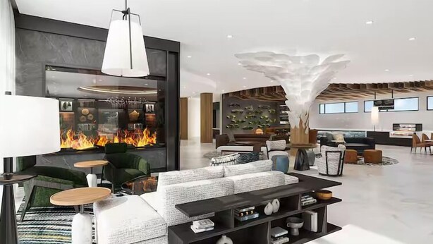 A modern hotel lobby with a fireplace, seating area, and a large decorative sculpture. - Tempo By Hilton Pigeon Forge (Pigeon Forge)