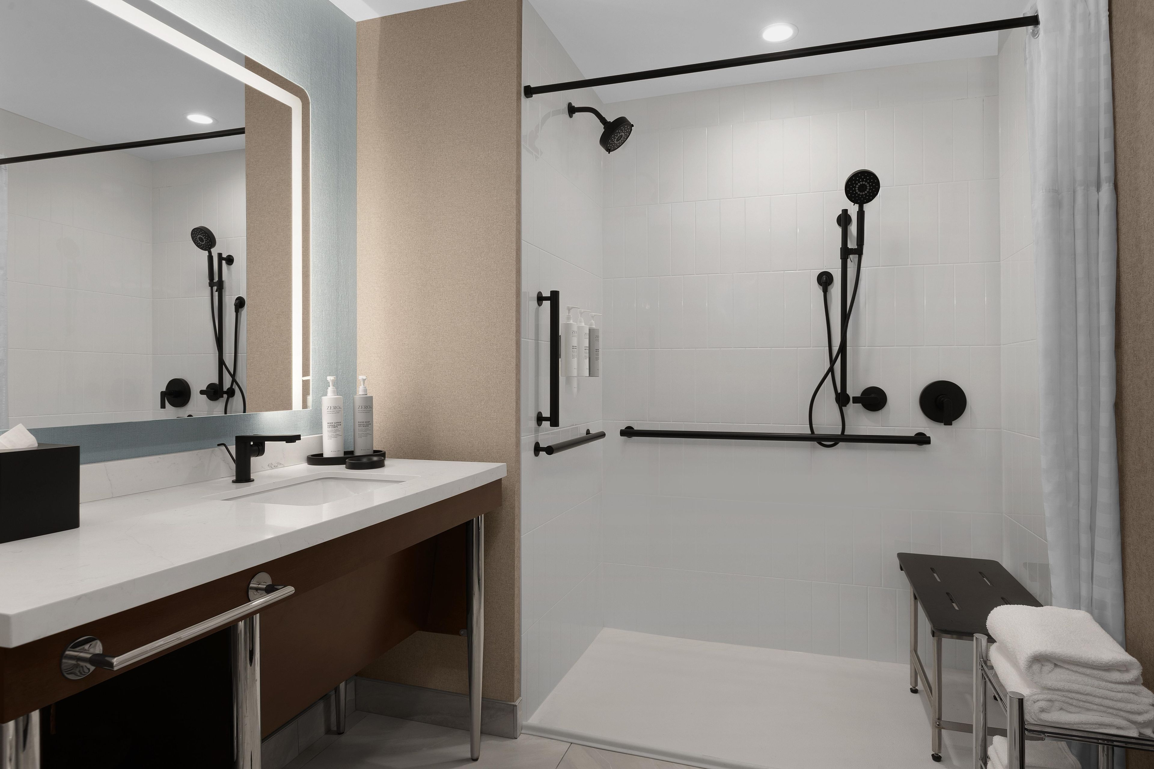 Ein modernes Badezimmer mit Dusche, Waschbecken und Spiegel.