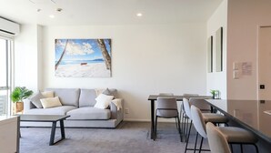 Una sala de estar moderna con un sof á, una mesa de centro y un comedor con sillas.