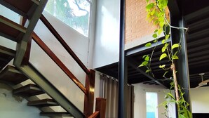 A staircase with wooden railings and a potted plant. - House with lounge balcony and panoramic view in Vargem Grande, (Vargem Grande Rio de Janeiro)