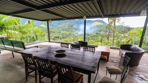 A dining area with a table and chairs, a bench, and a sofa. - House with lounge balcony and panoramic view in Vargem Grande, (Vargem Grande Rio de Janeiro)