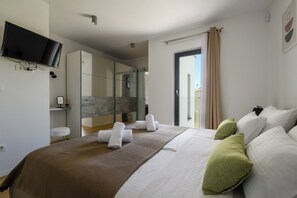 Relax in a spacious room with a large bed, flat-screen TV, and large mirror.
