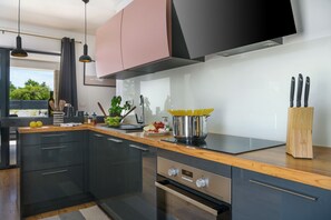 Enjoy cooking in this well-equipped kitchen with an oven, sink, and range hood.
