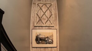 A staircase with a wooden wall and a framed picture.