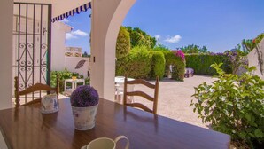 An outdoor patio with a wooden table, chairs, and a potted plant. - Bungalow - CalpePark (Calpe)