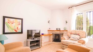 A living room with a fireplace, a television, and two armchairs. - Bungalow - CalpePark (Calpe)