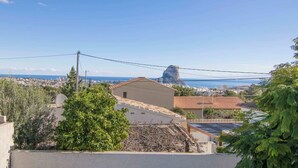 Zona residencial com vista para o mar e uma formação rochosa imponente.