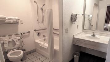 A bathroom with a toilet, shower, and sink.