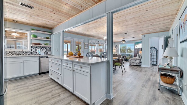 A spacious kitchen with wooden ceiling, white cabinets, and a large island. - COZY LIVING ON THE BEACH! (Gulf Shores)