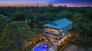 A two-story house with a large balcony, a swimming pool, and a well-maintained lawn. - ULTIMATE LUXURY ON THE WATER! PRIVATE POOL AND HOT TUB! (Gulf Shores)