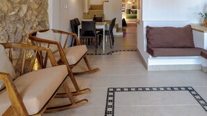 A spacious living area with a stone wall, wooden furniture, and a view to the dining area. - 2 BR Walled City Loft Jacuzzi - Downtown (Cartagena de Indias)