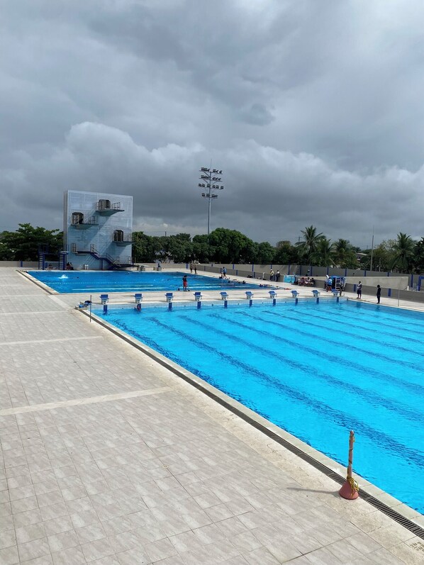 A swimming pool with a lifeguard tower and a building with multiple balconies. - Apartamento Boutique Cartagena Plaza  (Cartagena)