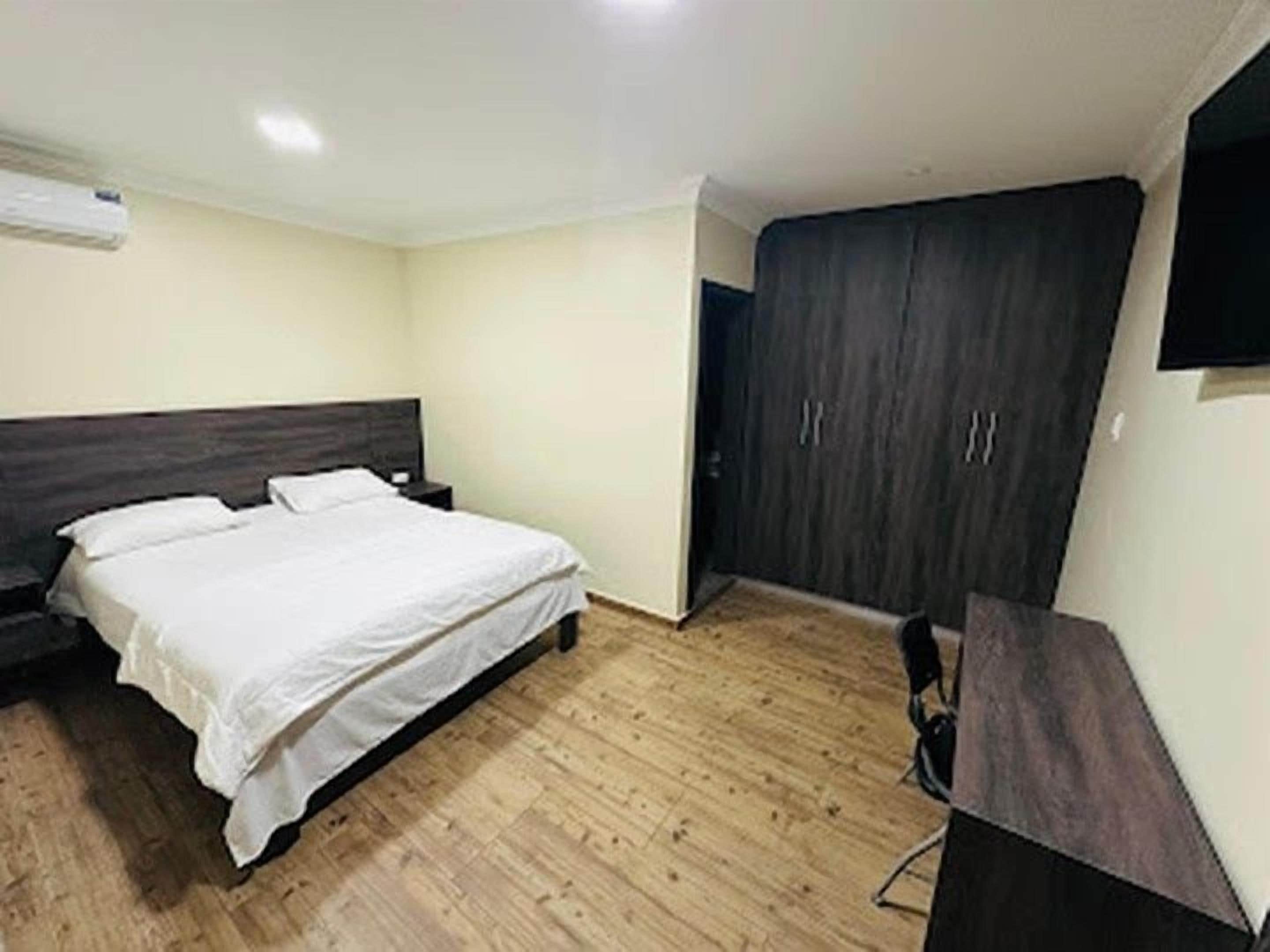 Un dormitorio con una cama, un armario y un escritorio.