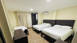 A hotel room with two single beds, a wooden floor, a desk, and a chair. - Hotel Vivanco's (Huaquillas)