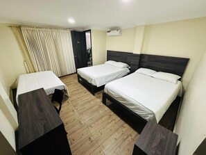 A hotel room with two single beds, a wooden desk, and a chair. - Hotel Vivanco's (Huaquillas)