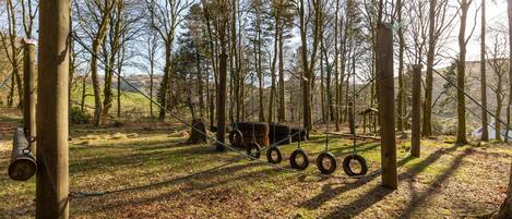A playground with tire swings and a wooden structure.