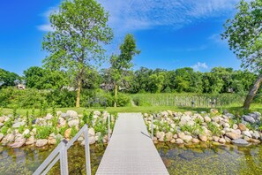 Stroll along the winding pathway to a serene pond surrounded by lush greenery and natural beauty.