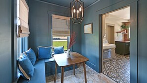 Una habitación con una pared azul, una mesa de madera y un banco con cojines azules.