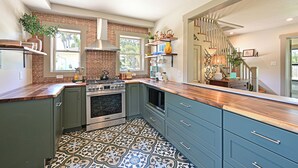 Una cocina con isla central, horno empotrado y salpicadero con diseño geométrico.