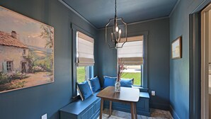 Una habitación con una zona de estar con banco integrado, una mesa y una lámpara colgante.