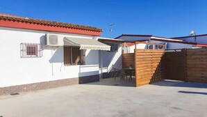 A residential building with a tiled roof, a balcony with a railing, and a wooden gate.