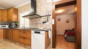 A kitchen with wooden cabinets, a microwave, a coffee maker, and a dishwasher.