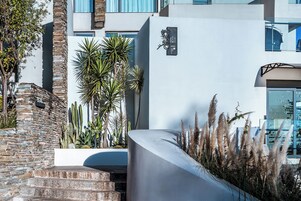 Un edificio moderno con fachada de piedra y techo plano, y un letrero con caracteres chinos.