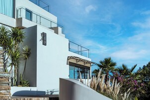Un edificio moderno con fachada blanca, ventanas grandes y un balcón.