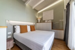 Ein ordentlich eingerichtetes Schlafzimmer mit einem großen Bett, einem Nachttisch, einer Lampe und einem Fenster mit Vorhängen.