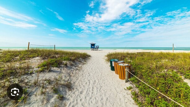 A beach path leading to a lifeguard tower, with trash bins and vegetation on either side. - Birdsong Pool Retreat - Pet Friendly - 7 Min to Beach (Venice)