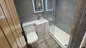 A modern bathroom with a toilet, sink, and glass-enclosed shower. - Apartmentsleeps6-familly&petfriendly (Manchester)