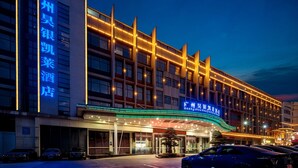 Un hotel con fachada moderna, señalización iluminada y una entrada bien iluminada.
