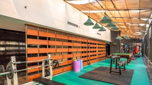 Et træningscenter med træbænke, styrketræningsudstyr og et poolbord.