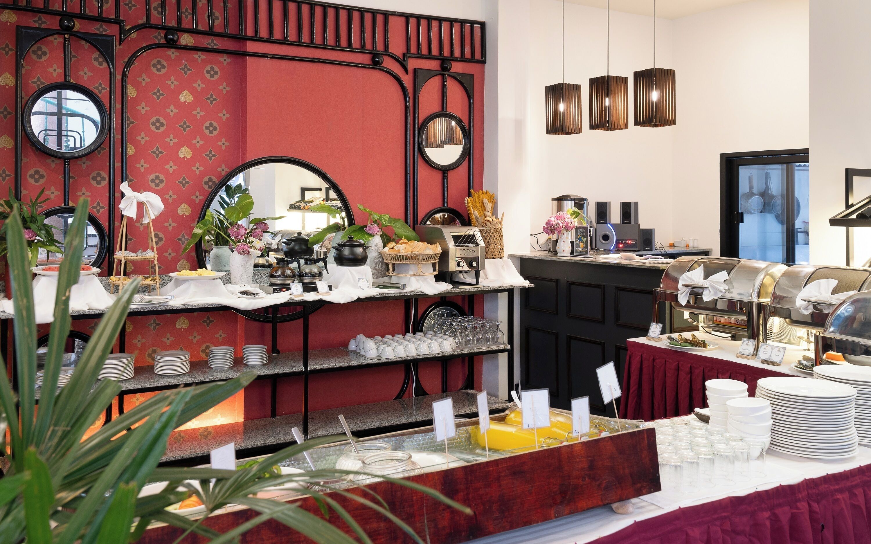 A buffet setup with various food items, a coffee station, and a mirror on the wall.