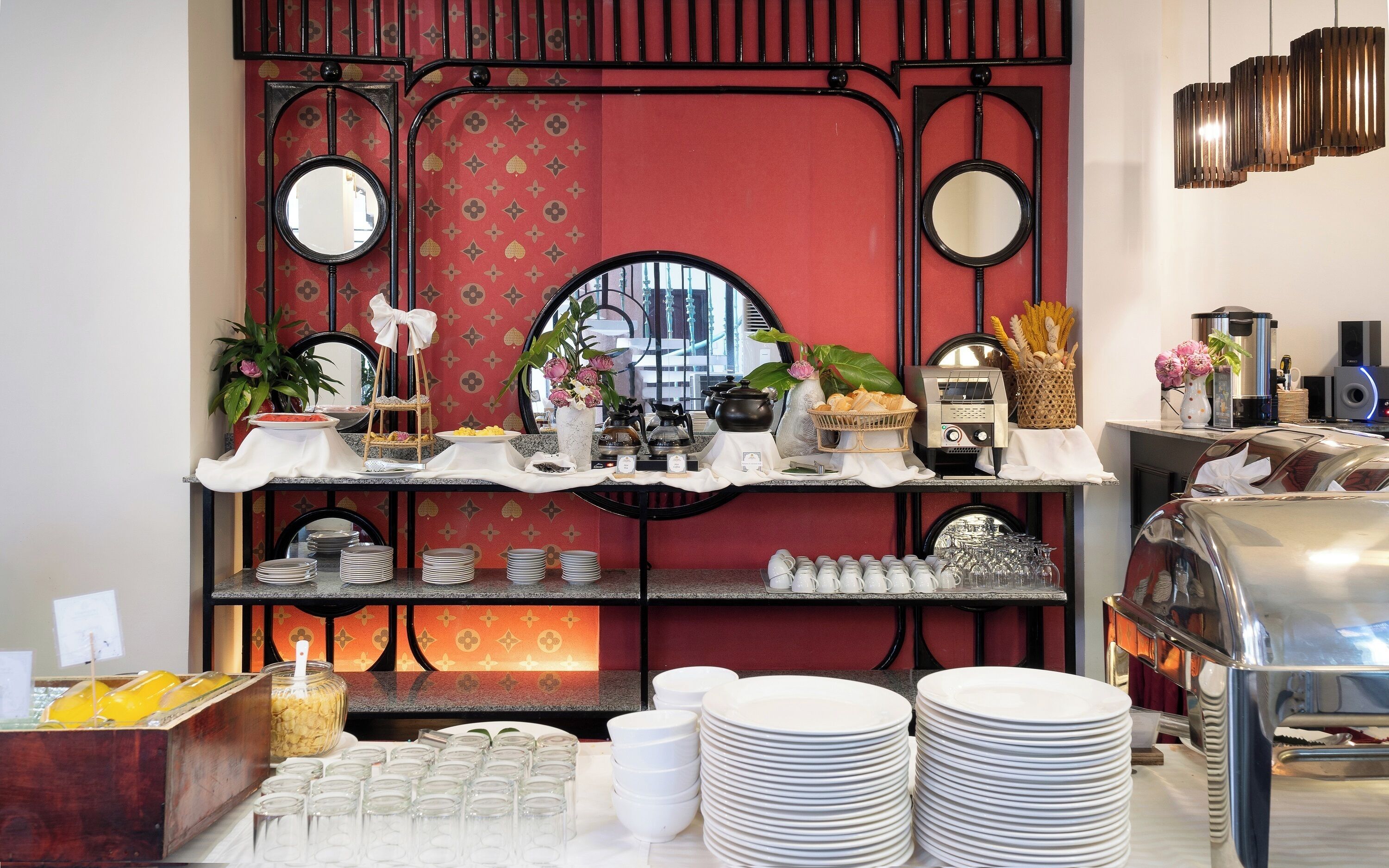 A buffet setup with various food items, plates, and utensils.