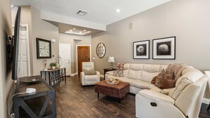 A living room with a sectional sofa, a coffee table, a TV, and a fireplace. - Charming 3-bedroom furnished, home with WiFi, AC in Spanish Hills Camarillo (Camarillo)