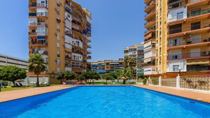 A swimming pool surrounded by multi-story residential buildings with balconies and air conditioning units. - Torre Copenhague - Terrace, Swimming Pool, Bechfront (Torremolinos)