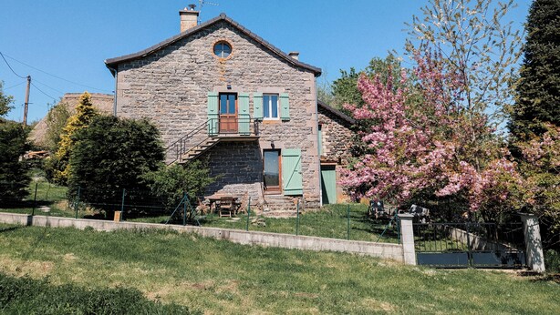 Una casa de piedra con un porche pequeño y una puerta de madera.