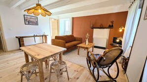 Una sala acogedora con una mesa de comedor de madera, un sofá marrón y un sillón mecededor.