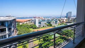 A high-rise building with a view of a port and cityscape.