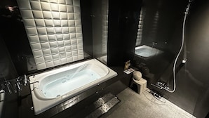 Un baño moderno con una bañera grande, cabina de ducha separada y un inodoro.