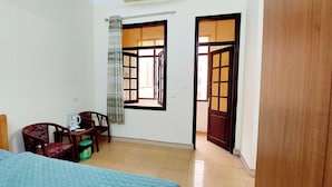 A bedroom with a bed, a desk, a chair, and a window with curtains. - SVFU Ha Noi (Hanoi)