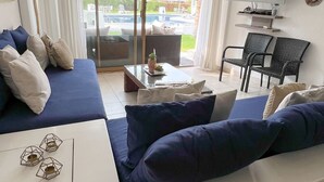 Un salon moderne comprenant un canapé, une table basse et un téléviseur fixé au mur.