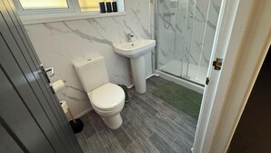 Ein Badezimmer mit Toilette, Waschbecken und Duschkabine.