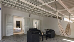 A spacious room with a high ceiling, a hanging hammock, and a bed with open shutters. - Sea View Apartment Terazza Grande, Selce, Croatia (Selce)