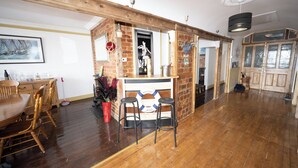 A wooden interior with a bar area, wooden chairs, and a dining table.